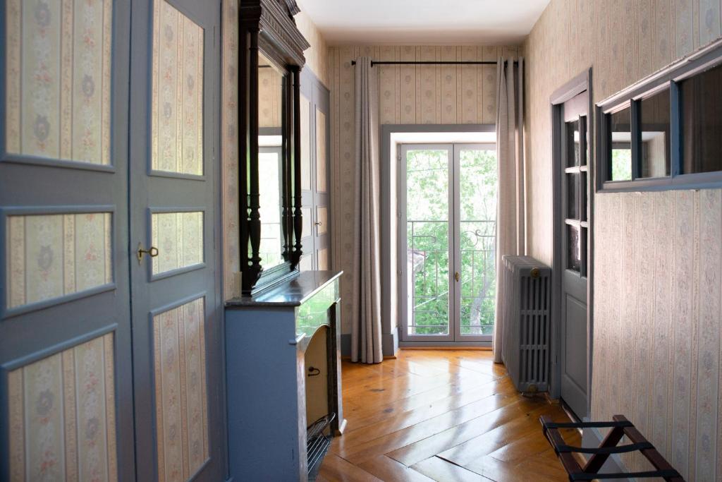 a hallway with doors and wooden floors and a window at Manoir le Roure in Châteauneuf-du-Rhône