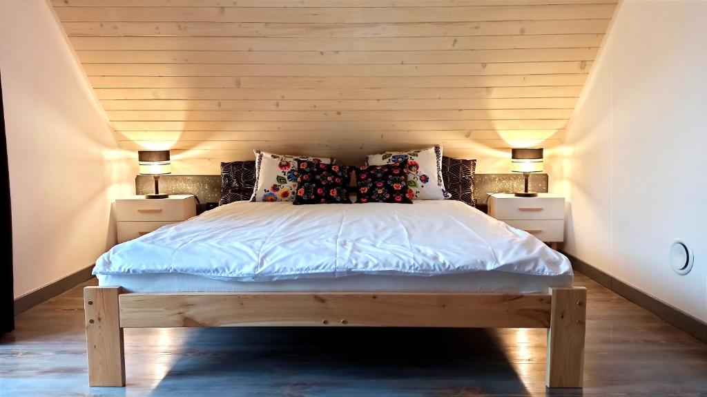 een slaapkamer met een bed met 2 nachtkastjes bij Domek w Poleskim Parku in Urszulin