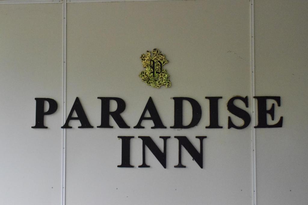 a sign on a door with a parakeet im at Paradise Inn in Kandy