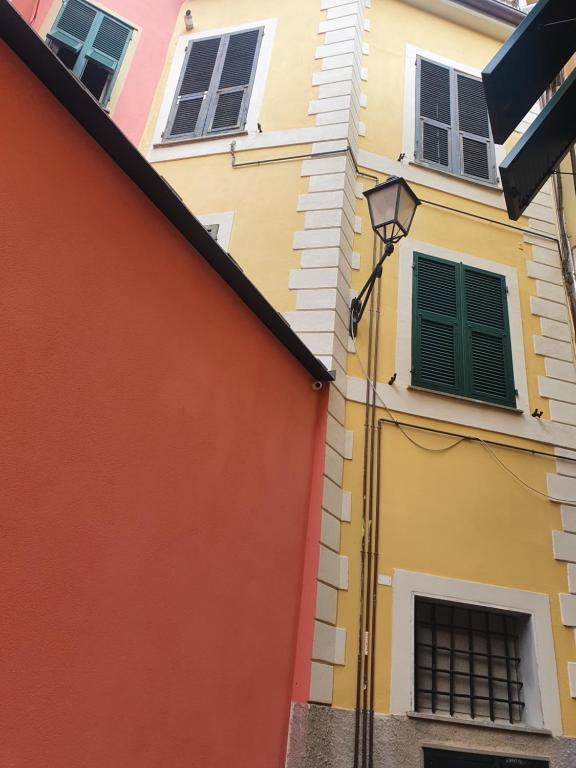 um edifício amarelo e laranja com persianas verdes em Casa Isabella De Luxe Studio em Monterosso al Mare