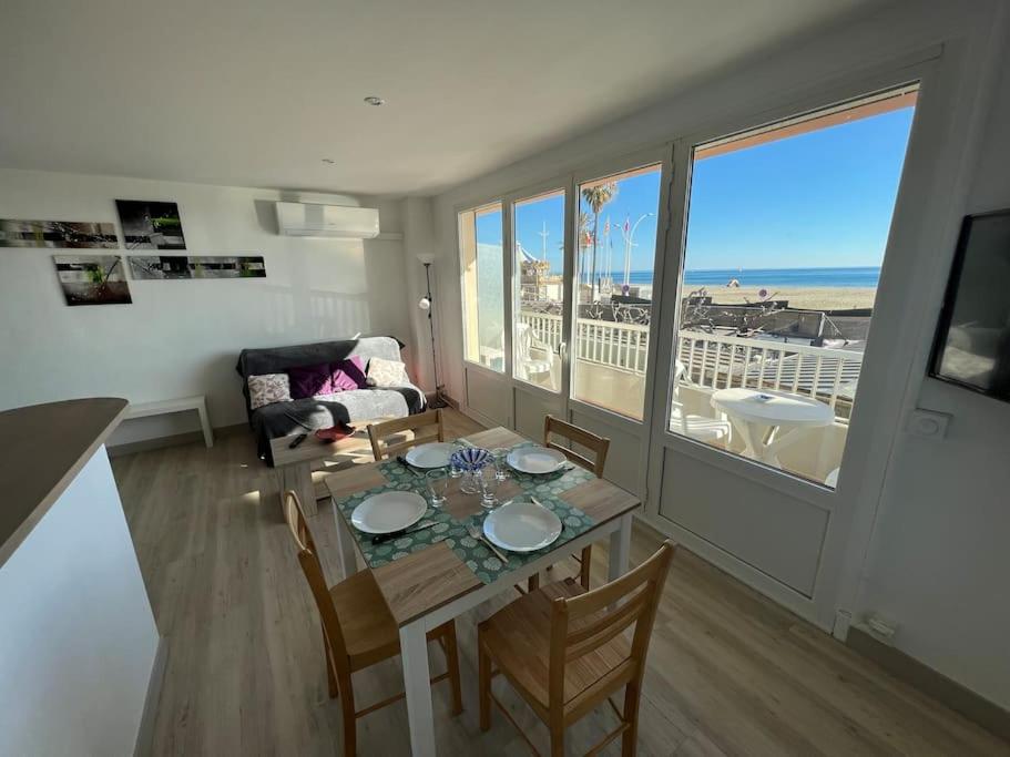 a living room with a table and a view of the ocean at Le CARROUSEL - Apt VUE MER - Plage à 10 M - CLIM - WIFI in Canet-en-Roussillon