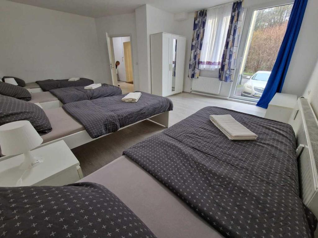 a room with four beds with blue sheets and a window at Ferienwohnung mit Smart-TV in Burscheid
