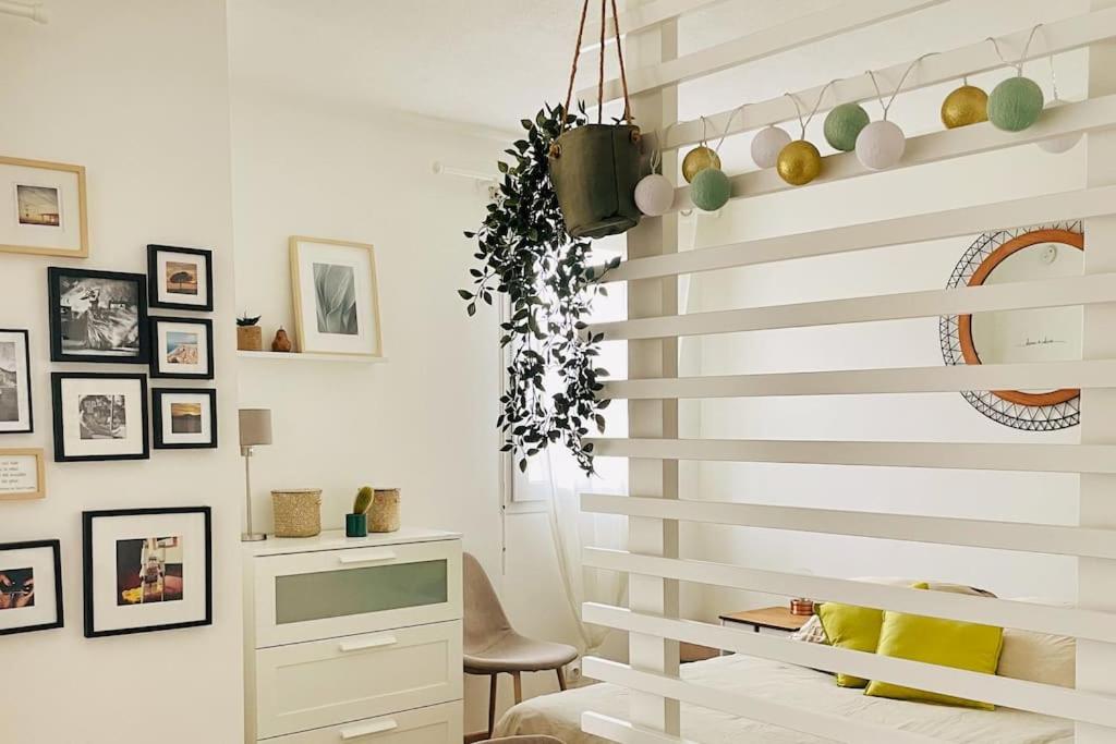 een woonkamer met een witte muur en een trap bij Studio Cosy avec terrasse Saint-Laurent du Var limite Nice in Saint-Laurent-du-Var