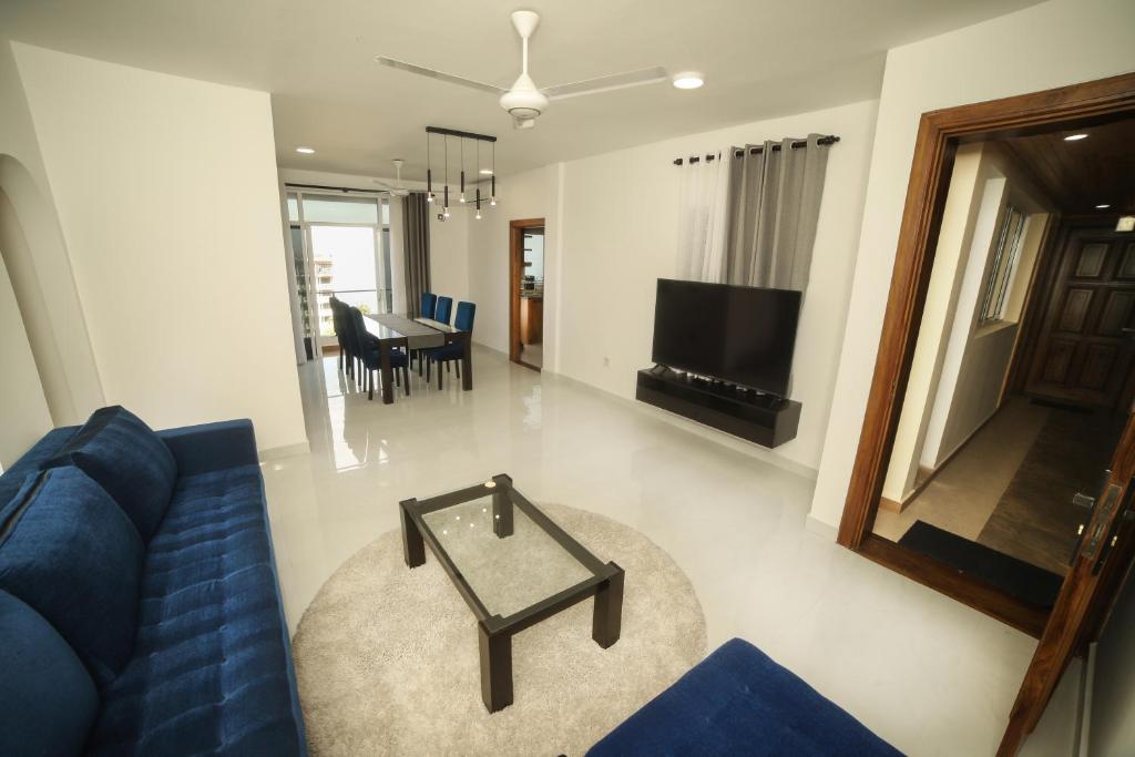 - un salon avec un canapé bleu et une table dans l'établissement BNB RESIDENCIES MOUNT LAVINIA, à Dehiwala-Mont Lavinia