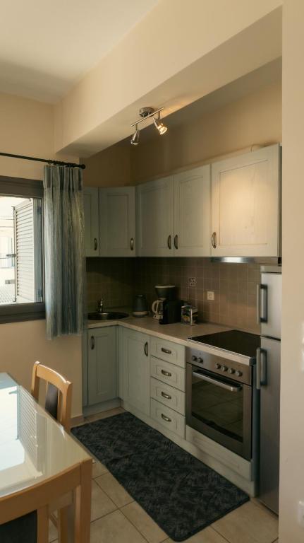 a kitchen with white cabinets and a stove top oven at Baia Blu Apartments in Syvota