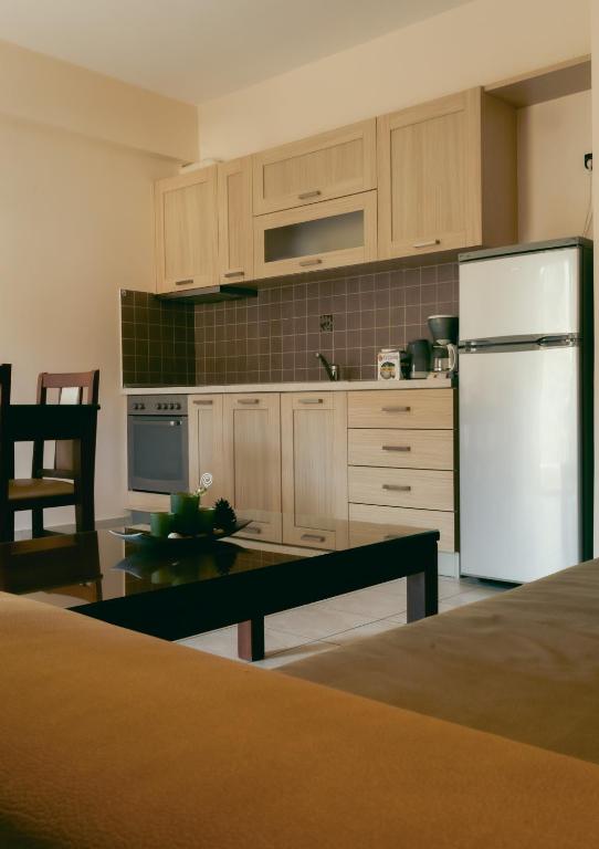 a kitchen with a white refrigerator and a table at Baia Blu Apartments in Syvota