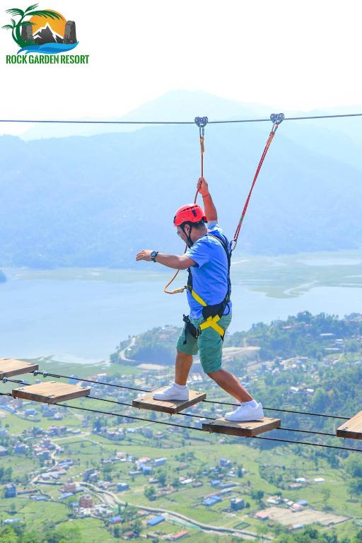 a man walking on a zip line in the air at Rock Garden Resort in Pokhara