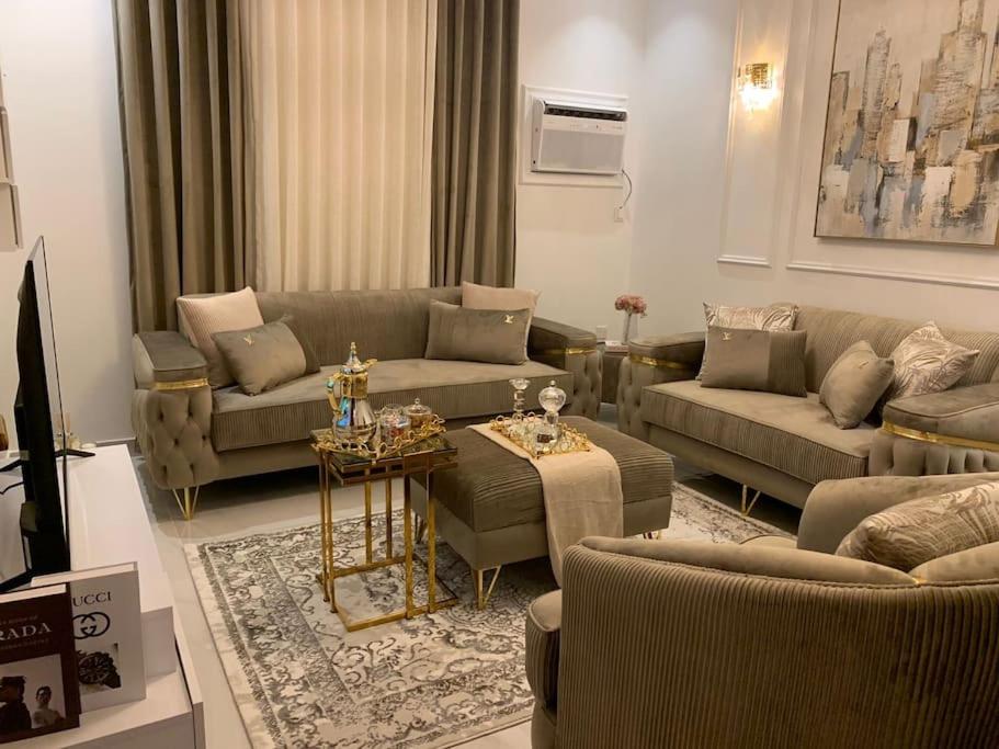 ein Wohnzimmer mit zwei Sofas und einem Tisch darin in der Unterkunft luxury apartment - Prince majed park in Dschidda
