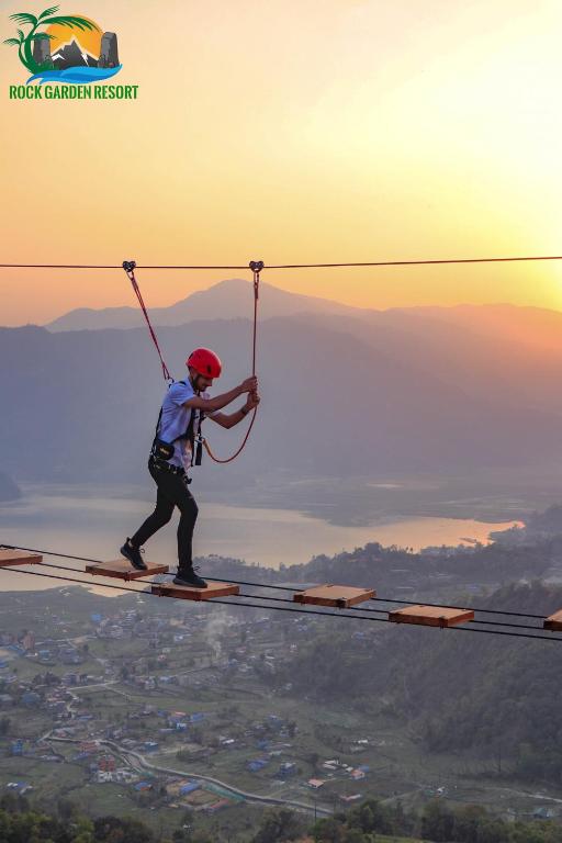 a person riding on a zip line in the sky at Rock Garden Resort in Pokhara