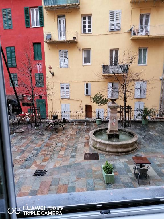 une cour avec une fontaine devant un bâtiment dans l'établissement Vattelapesca, à Bastia