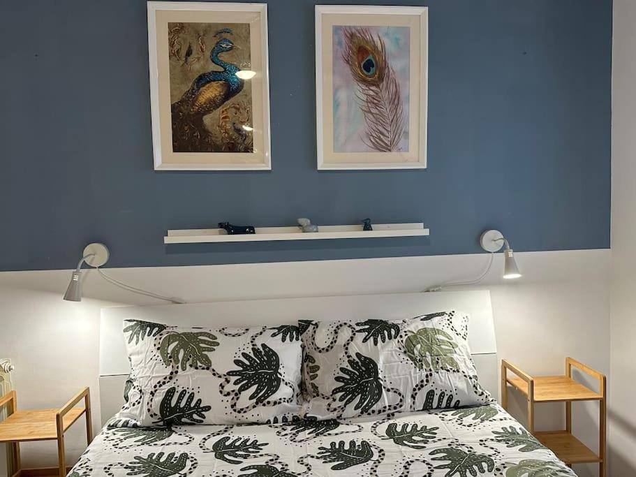Un dormitorio con una pared azul y una cama con almohadas en Casa Rostri, en Lido di Ostia