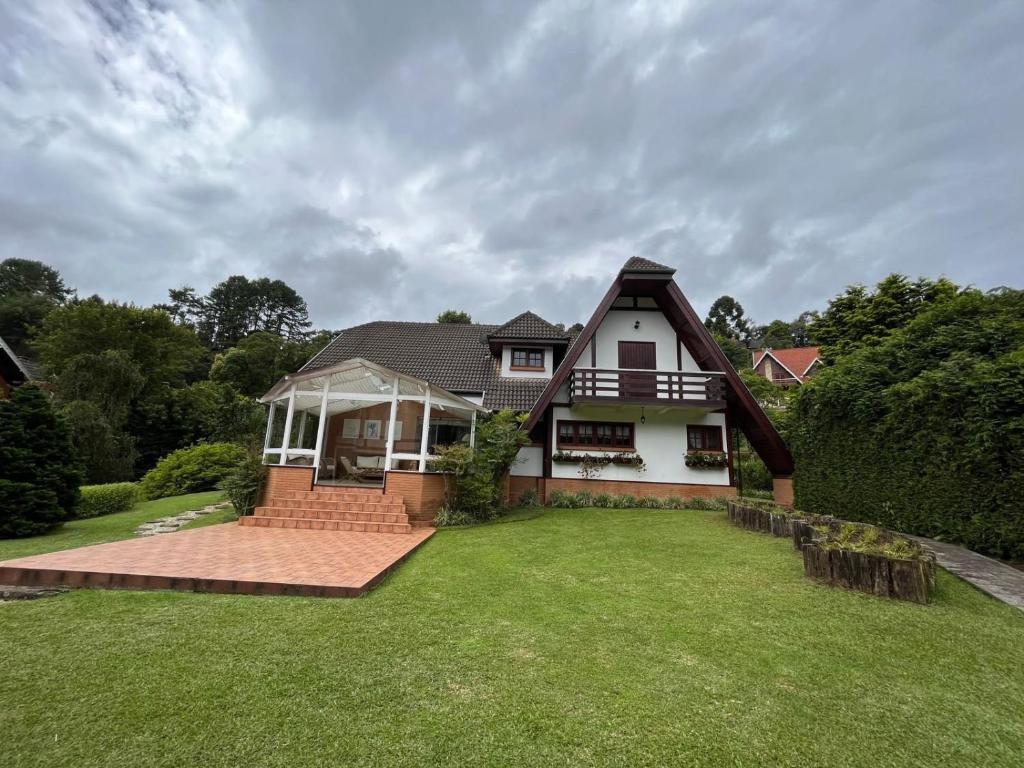 a house with a large lawn in front of it at Villa di Caserta by Capivari Lodge Home in Campos do Jordão