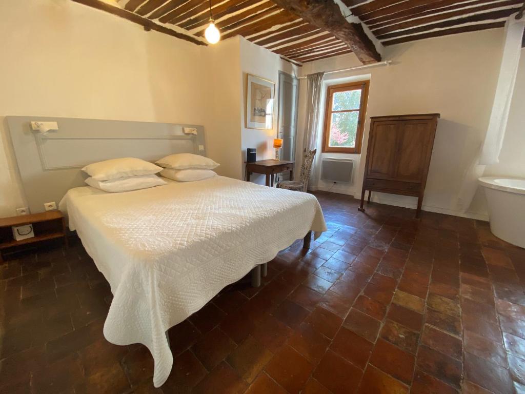 a bedroom with a white bed in a room at Campagne Salettes in Lorgues