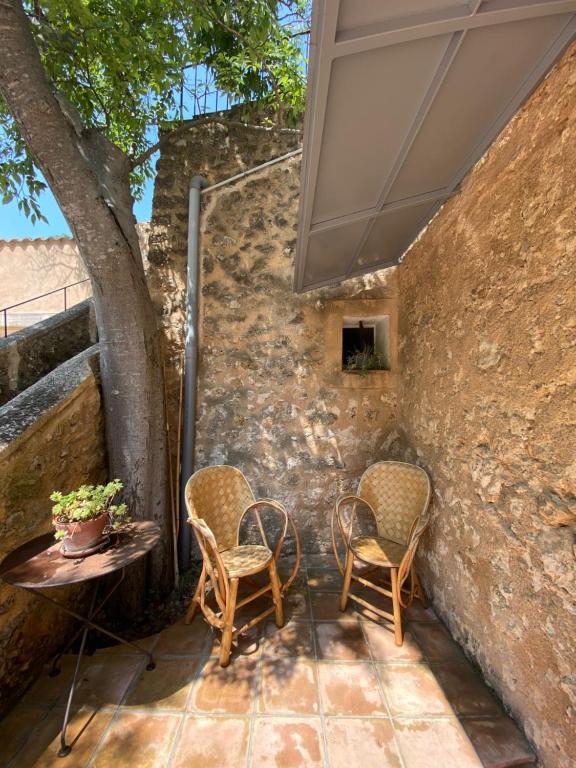 a patio with chairs and a table and a stone wall at Campagne Salettes in Lorgues