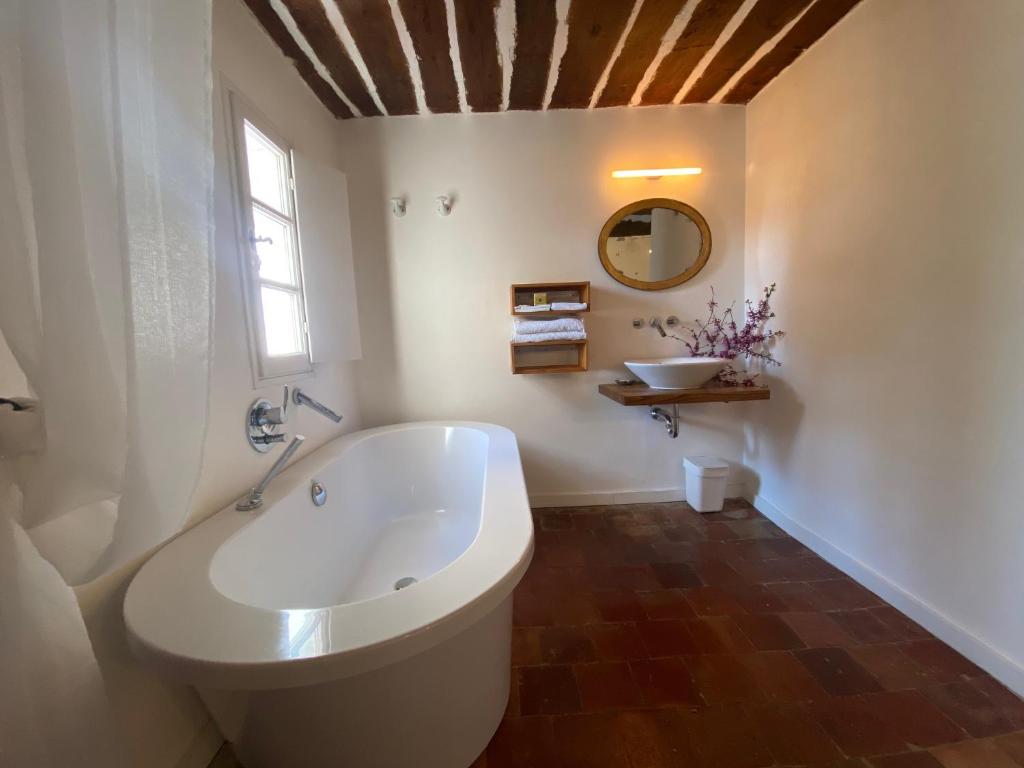 a bathroom with a large white tub and a window at Campagne Salettes in Lorgues
