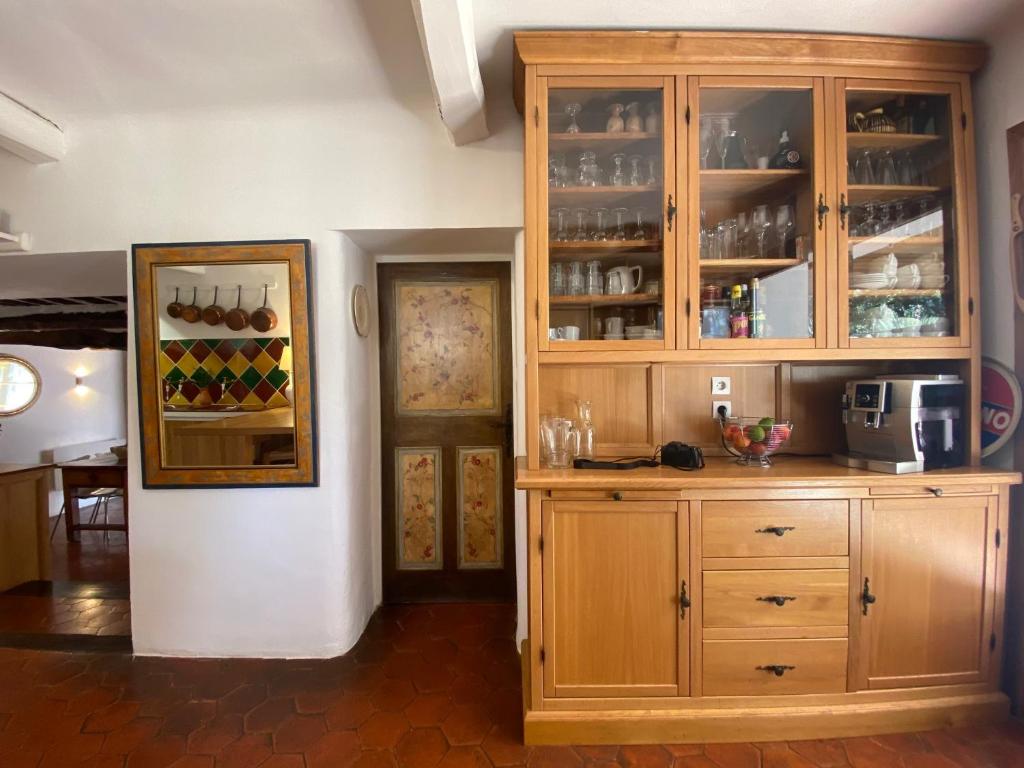 a kitchen with a large wooden cabinet with glasses at Campagne Salettes in Lorgues