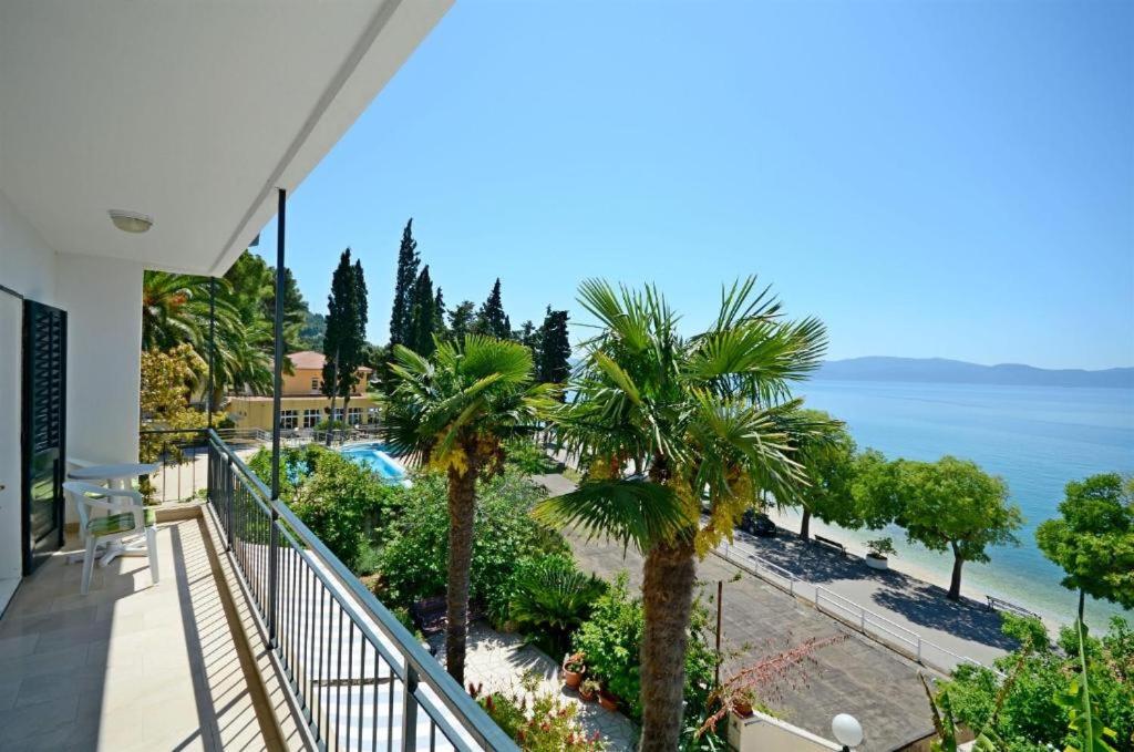 a balcony with palm trees and the ocean at Lui in Gradac