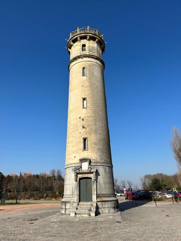 オンフルールにあるLes Apparts du Phareの道路脇に腰掛けた高い石造りの灯台