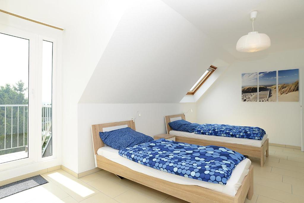 two beds in a room with a window at Top-Ferienwohnungen in Heiligenhaus in Heiligenhaus