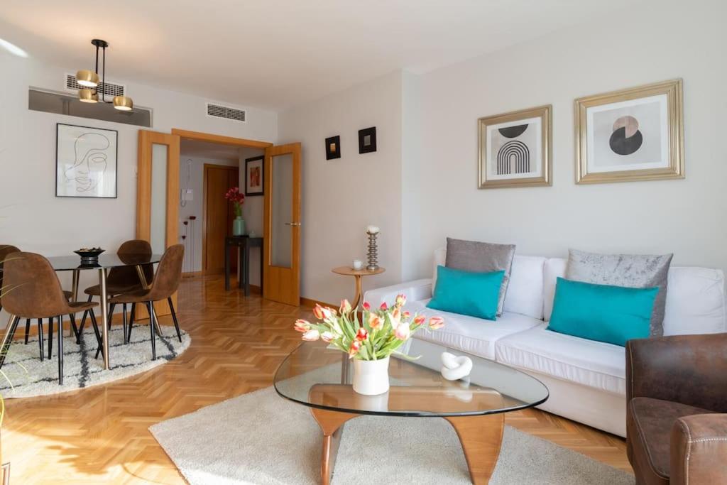 salon z białą kanapą i stołem w obiekcie Vivienda con zona de trabajo, piscina y parking w Madrycie