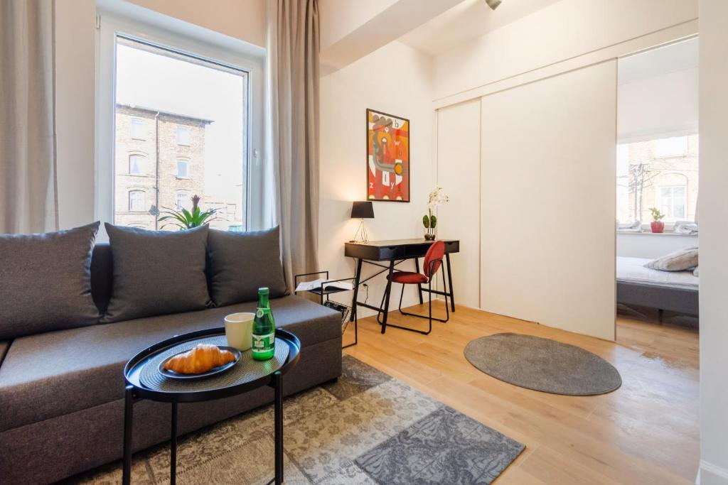 una sala de estar con un sofá y una mesa en Apartamenty KTW, en Katowice