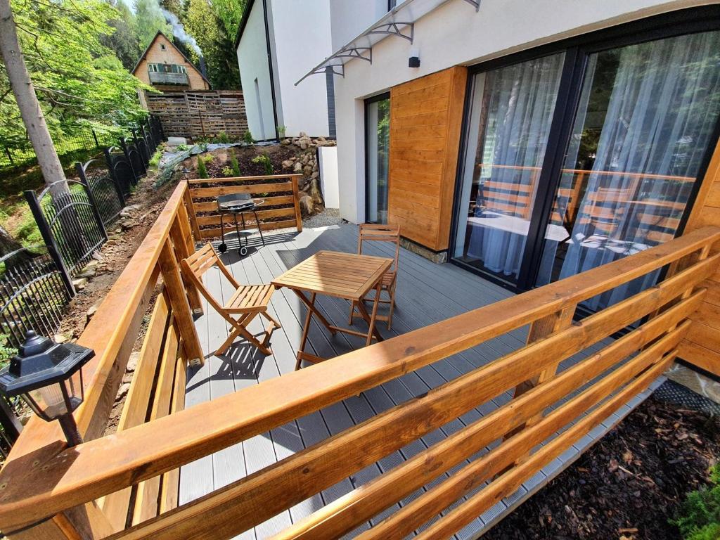 a balcony with a wooden railing and tables and chairs at Apartamenty EverySky - Dom Reymonta 9 in Karpacz