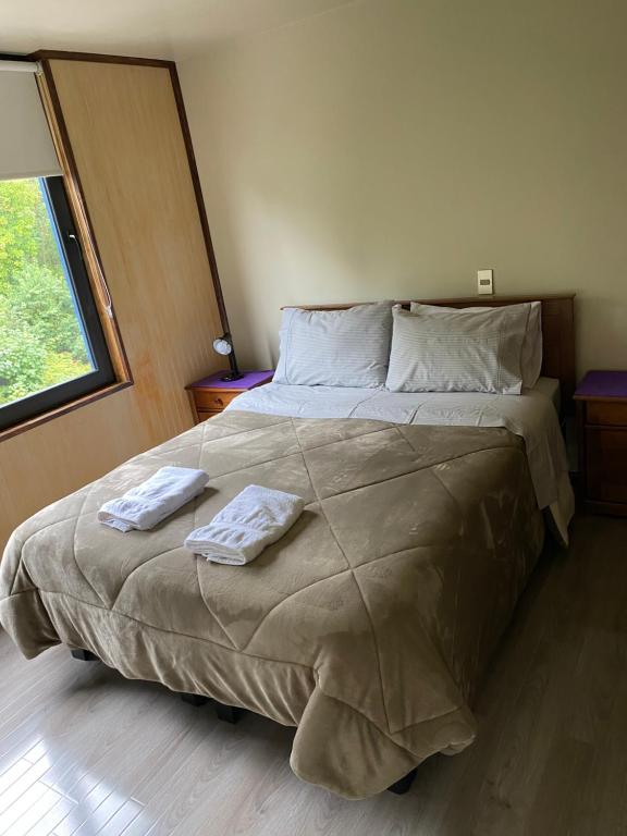 sypialnia z dużym łóżkiem z dwoma ręcznikami w obiekcie DEPARTAMENTO 2 EN PLENO CENTRO DE PUERTO MONTT w mieście Puerto Montt