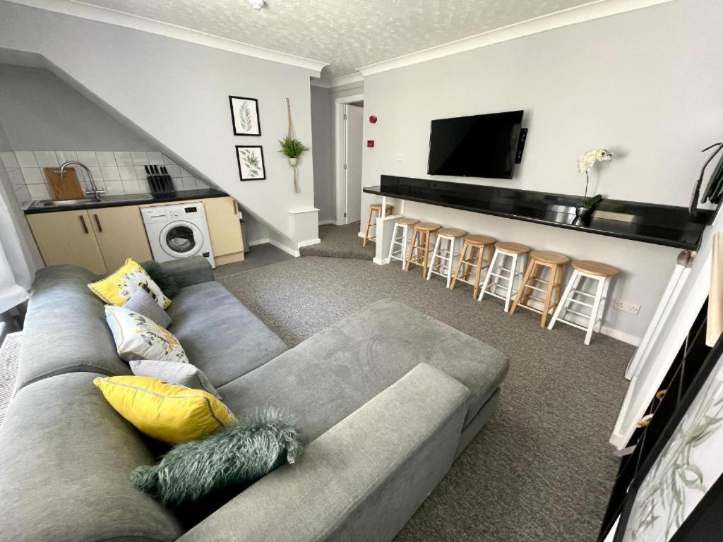 sala de estar con sofá gris y cocina en LuXe Apartments Kemptown en Brighton & Hove
