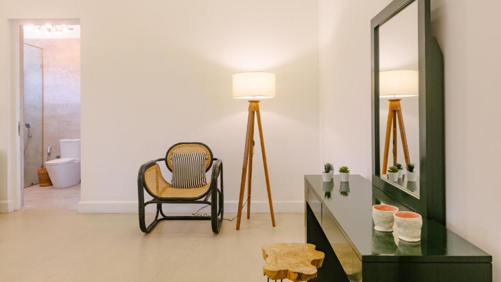 - un salon avec une chaise et un miroir dans l'établissement Fairy Cottage Kandy, à Kandy