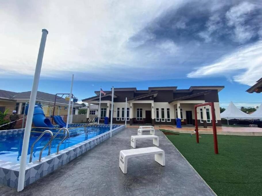 un resort con piscina e parco giochi di Aja Retreat Chalet a Jitra