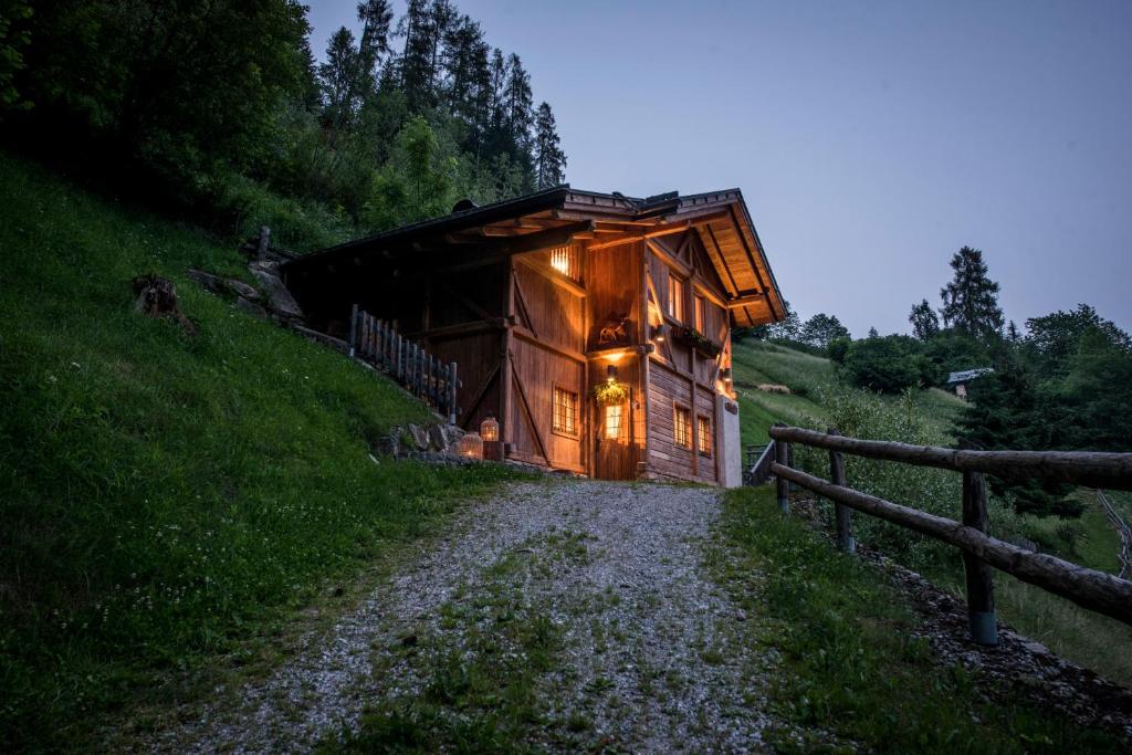 a log cabin on a hill with lights on at Chalet Bambi in Rabbi