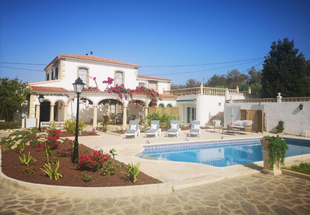 a large house with a swimming pool in front of it at Suites in Ca Olivar, Moraira in Teulada
