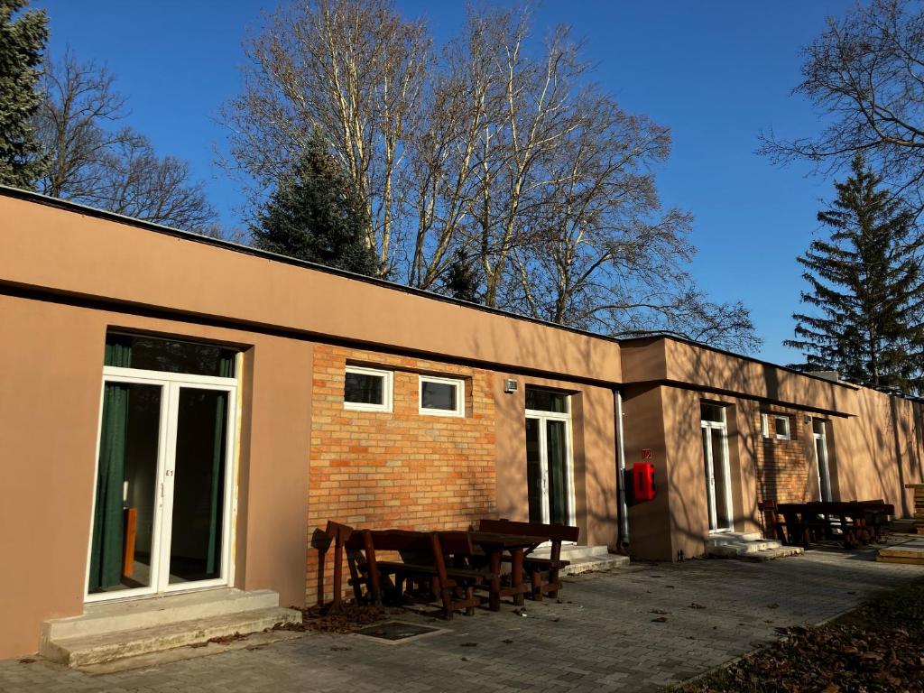 un bâtiment avec une table et des chaises devant lui dans l'établissement Öreg-tó Youth Hostel, à Tata