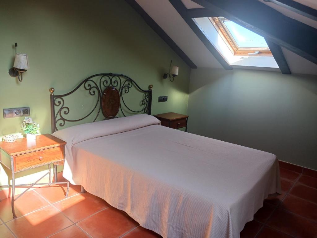 a bedroom with a white bed and a window at Hotel Restaurante Doña Elvira in Nava del Rey