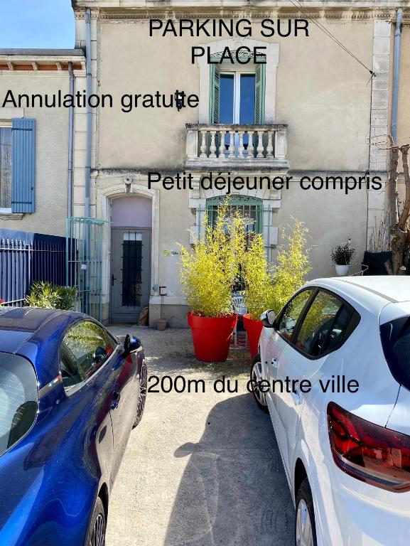 deux voitures garées devant un immeuble dans l'établissement Côté Court, à LʼIsle-sur-la-Sorgue