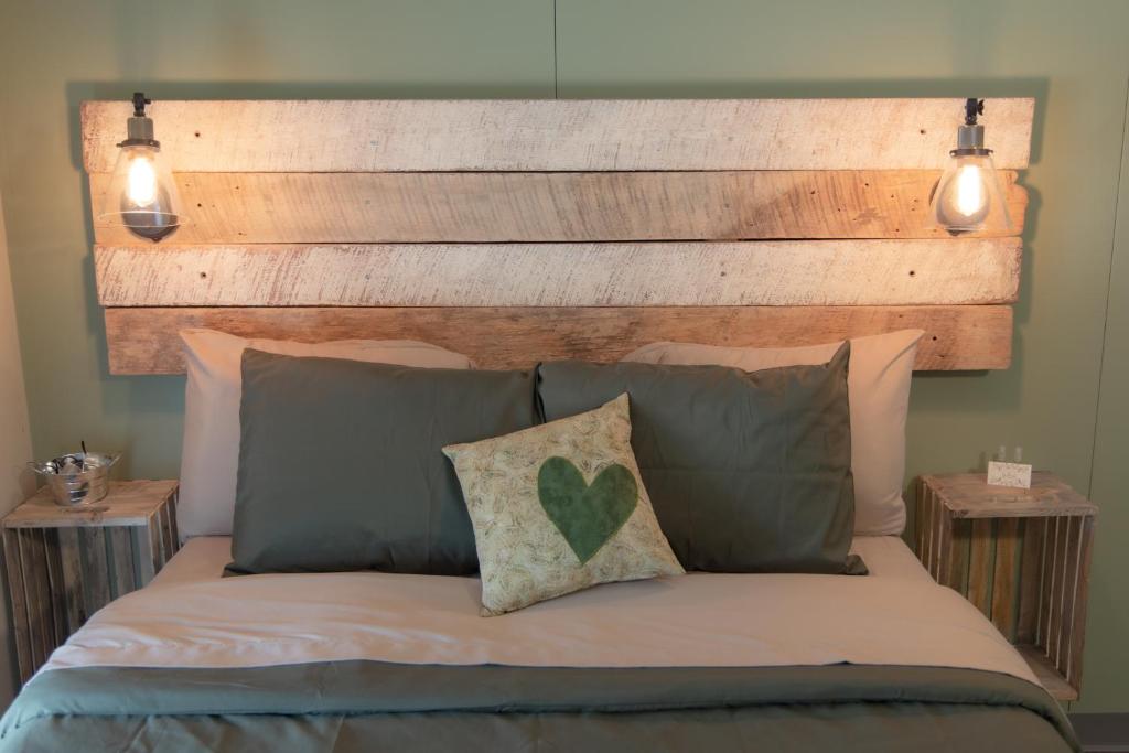 - un lit avec une tête de lit et des oreillers en bois dans l'établissement The Green Heart Inn, à Kingsville