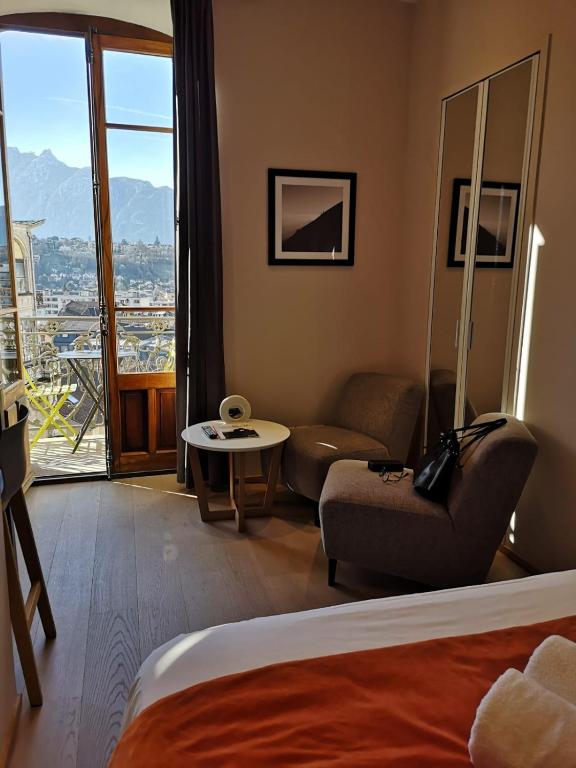 a hotel room with a bed and a couch and a window at Villa Saint Enogat in Aix-les-Bains