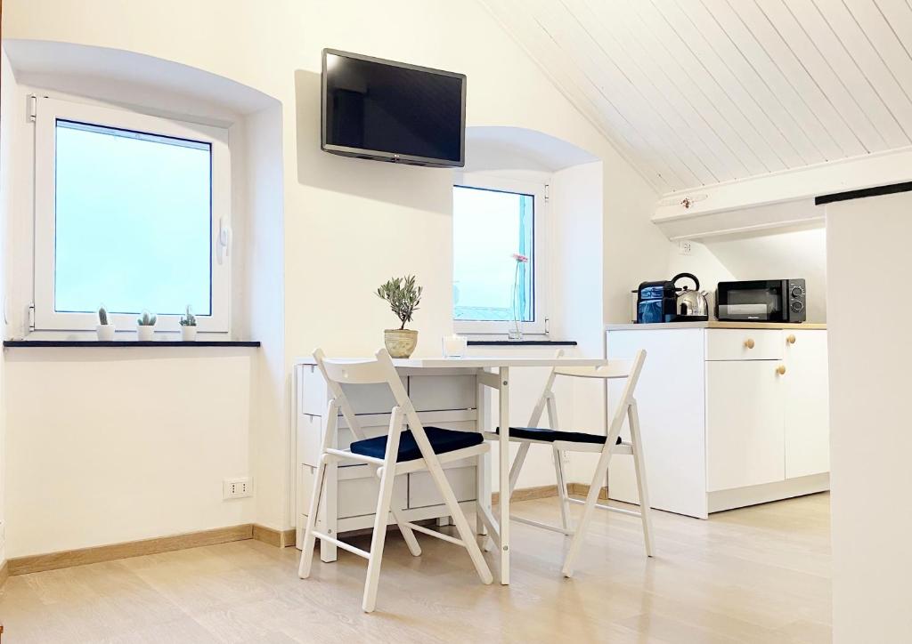 a white kitchen with a table and two chairs at La Finestra Sull’Oasi in Genoa