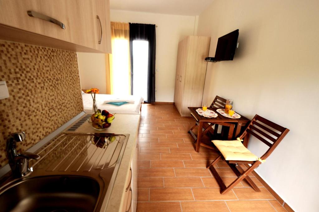 eine kleine Küche mit einem Tisch und einem Kühlschrank in der Unterkunft Alba Studio Thassos in Kinira