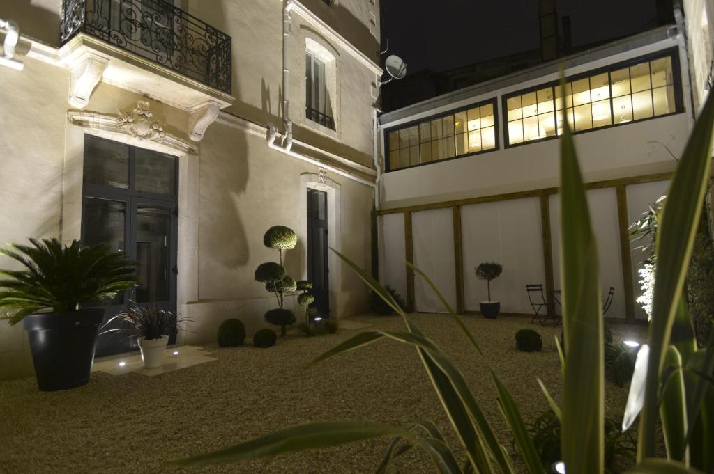 een lege binnenplaats met potplanten en een deur bij France Hôtel in Niort