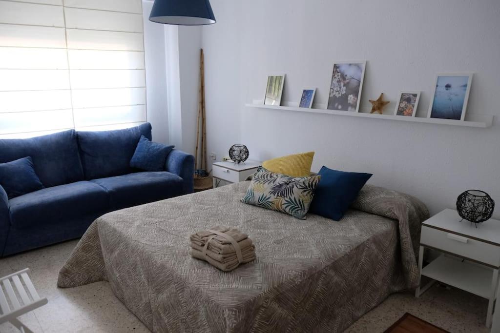 a bedroom with a bed and a blue couch at Apartamento “Las Calmas” en Huesca in Huesca
