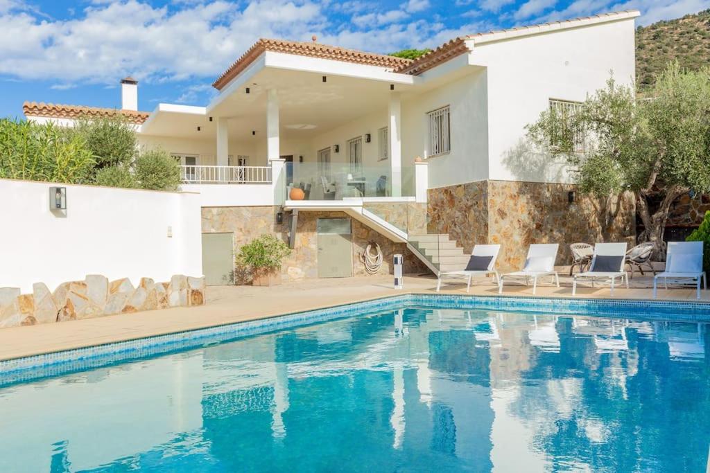 a villa with a swimming pool in front of a house at V022 - VILLA ELS OLIVARS in Pau