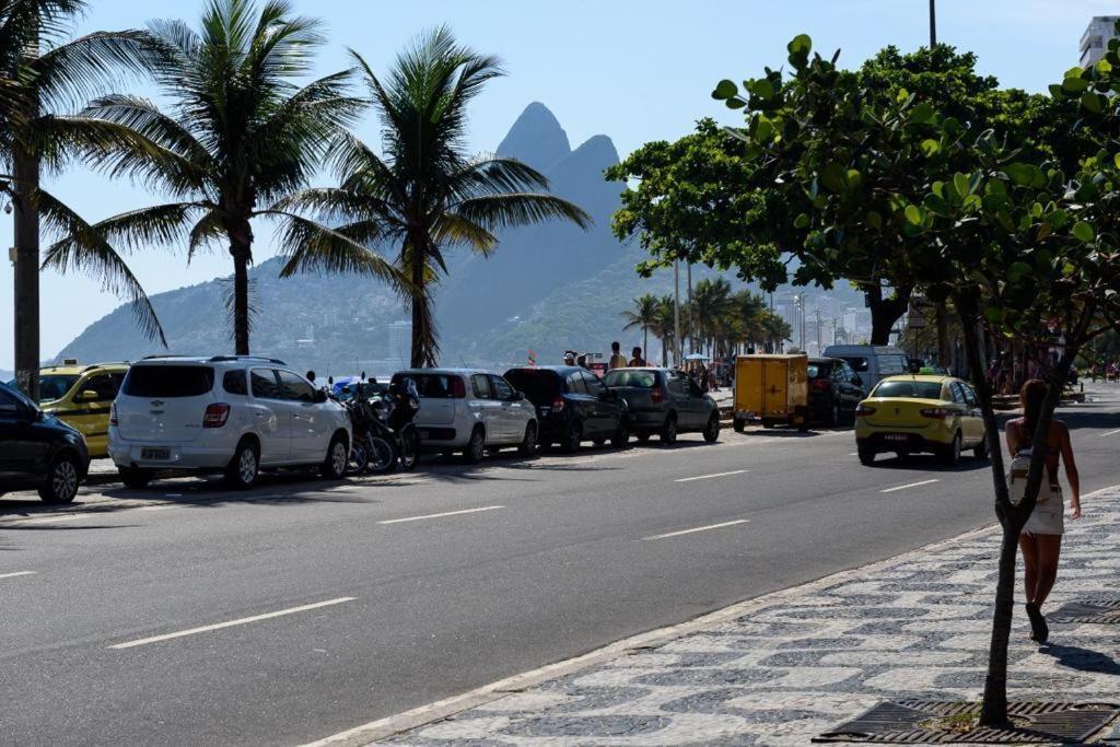 a street with cars parked on the side of the road at Ipanema avenida Vieira Souto in Rio de Janeiro
