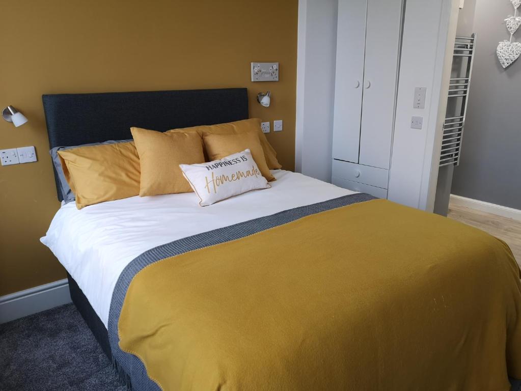 a bedroom with a large bed with a yellow blanket at Double Ensuite Bedroom near Edinburgh in Kirkcaldy
