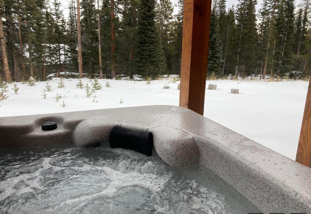 a jacuzzi tub in the snow with a view of a forest at NEW HOT TUB! Secluded, tucked away cabin in Fairplay