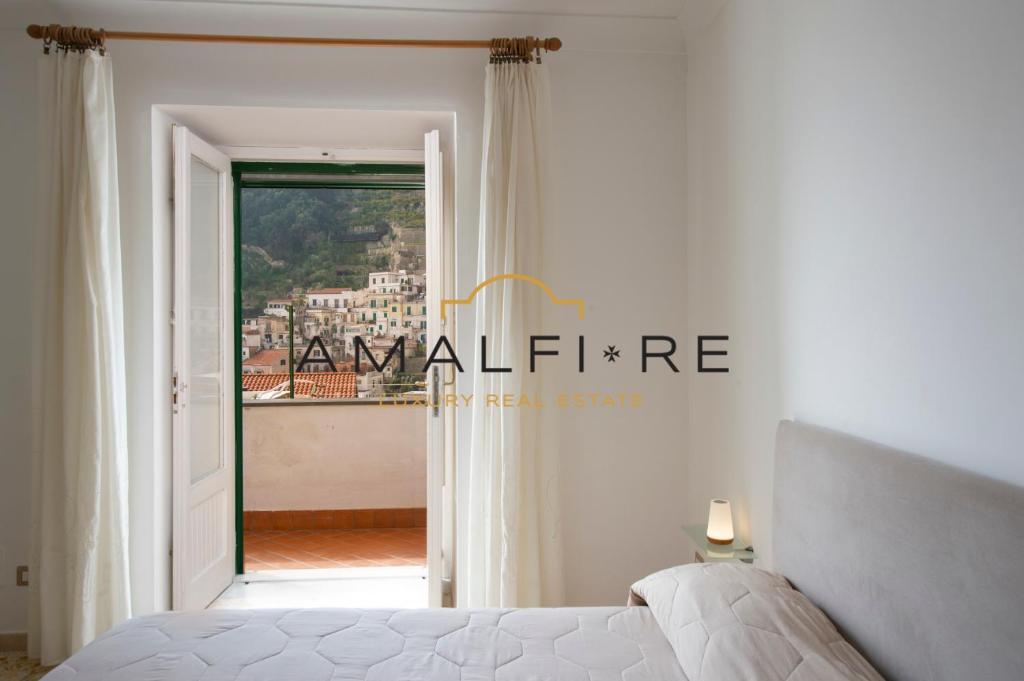 a bedroom with a bed and a view of a city at Casa Smeraldo in Amalfi