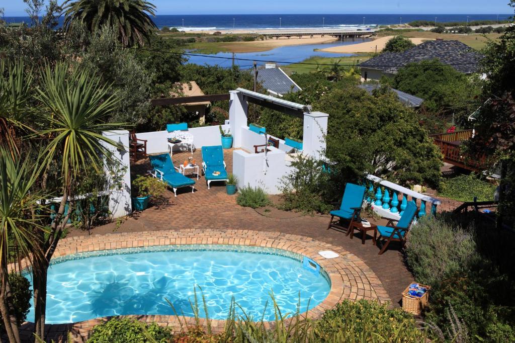 an image of a swimming pool with blue chairs around it at Mont Fleur B&B in Wilderness