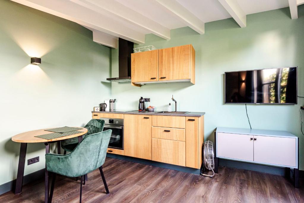 une cuisine avec une table, des chaises et une table ainsi qu'une télévision dans l'établissement Zandvoort Lodge, à Zandvoort