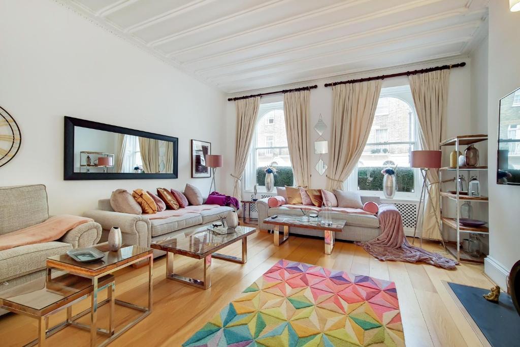a living room with two couches and a colorful rug at The Belgravia Residences in London