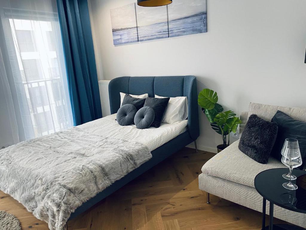 - une chambre avec un lit bleu et un canapé dans l'établissement Wileńska home apartment 2, à Varsovie